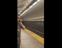 Man in suit carries silver metal tubes in subway station