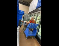 Old woman pushes other lady on cart in market 
