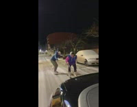 Two people dragged by a car while standing on boards on icy road