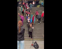 Women wave down the stairs for video