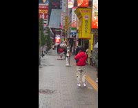 Man in sleeveless jacket sidewalk video shoot