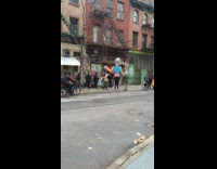tall blue and silver puppet waving hand in street