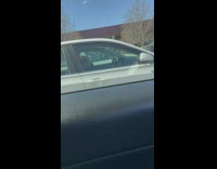 Woman fixes hair for a selfie inside parked car