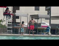 Little boy holding hands with guy as they prep to belly flop in pool
