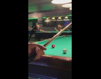 Two guys taking pictures while holding pool stick