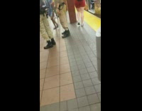 Two guys in Ghostbuster uniforms costumes walk around subway station