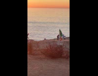 Woman Christmas tree costume poses at cliffs