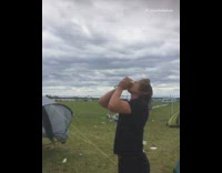 Guy in black at festival cracks beer over head and chugs it 
