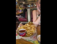 Guy in restaurant holding dates foot in booth