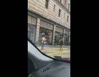 Woman in yellow coat with coffee on the sidewalk