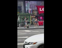 Woman in jean shorts tiktok dance at the sidewalk