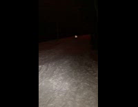 Person sliding down hill on sled off a ramp