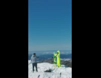 Woman in green snowboard outfit raise hands