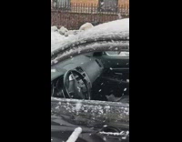 Parked black car with window down snow