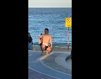 Man shirtless tiktok dance at beach park