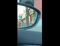 Guy drags orange traffic cone down sidewalk 