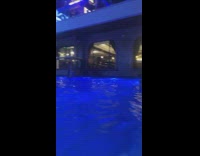 Woman in white dress models by the poolside