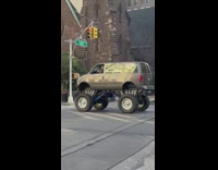 Guy drives a van with monster truck wheels 