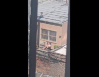 Bald man sunbathing on balcony