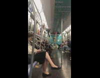 Boy striped shirt climbs and hangs from tall handrail on subway train