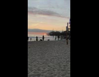 Woman does handstand at beach for picture