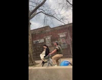 Couple rides bike woman sits in basket