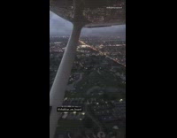 Guy flies airplane as sun sets city 