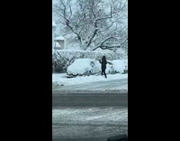 Woman hits car window with cloth to get snow off 