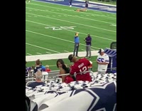 Woman in red outfit with black wings poses on the stadium chairs