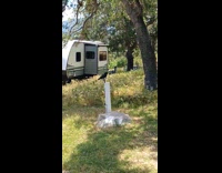 Crow Leans Body Forward to Drink Water from Spigot