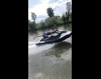 Guy riding jet ski with superman pose at high speed