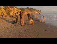 Young girl dress rock beach film crew