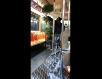Man holds tall tree plant in pot on subway train