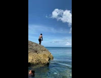 Man shirtless jumps to the ocean from the rock