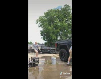 Girl car wash plays with high pressure hose