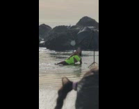 Woman in green dress lie down sideways at the beach shore Part 1