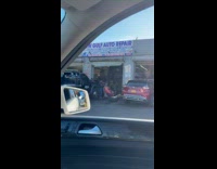 Man getting haircut at auto repair shop