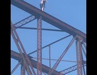 guy jumps off red bridge into water