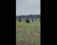 People holding sticks practice martial arts park