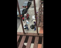 Drumline team purple uniform play drums on the street while kids dance