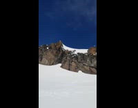 Skiier jumps off cliff and keeps sliding after land