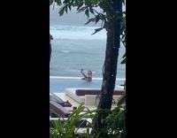 Woman in pool selfie while it rains