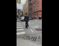 Tall person black coat cross the street