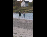 Brown sweater girl poses beach white house