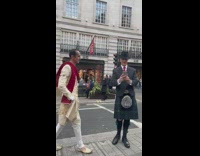 Man in a royal outfit poses on the street