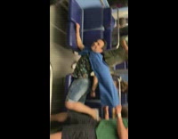 Guy with blue cape lays on bus seats and does superman pose