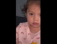 Baby girl tries popcorn with hot sauce