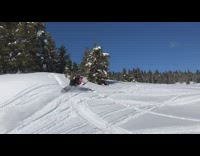 Guy drives ski mobile, does a jump, and flies off