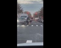 Guy crossing crosswalk carrying giant light post