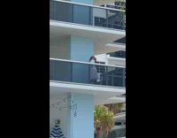 Woman lift white robe show butt balcony pool